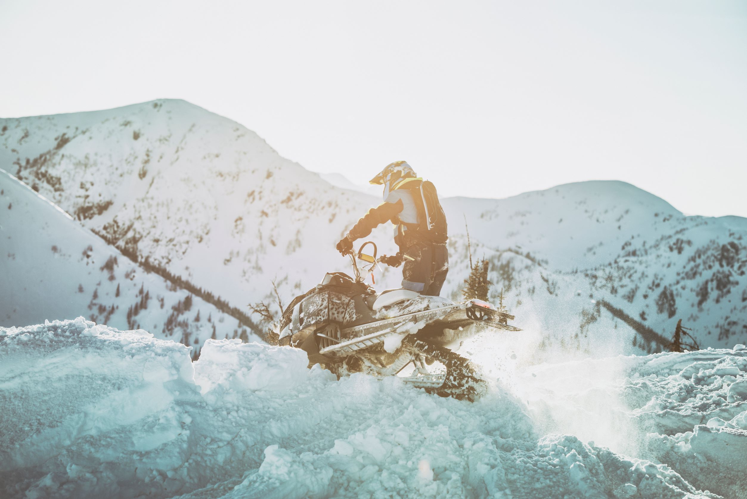 Person snowmobiling in mountains